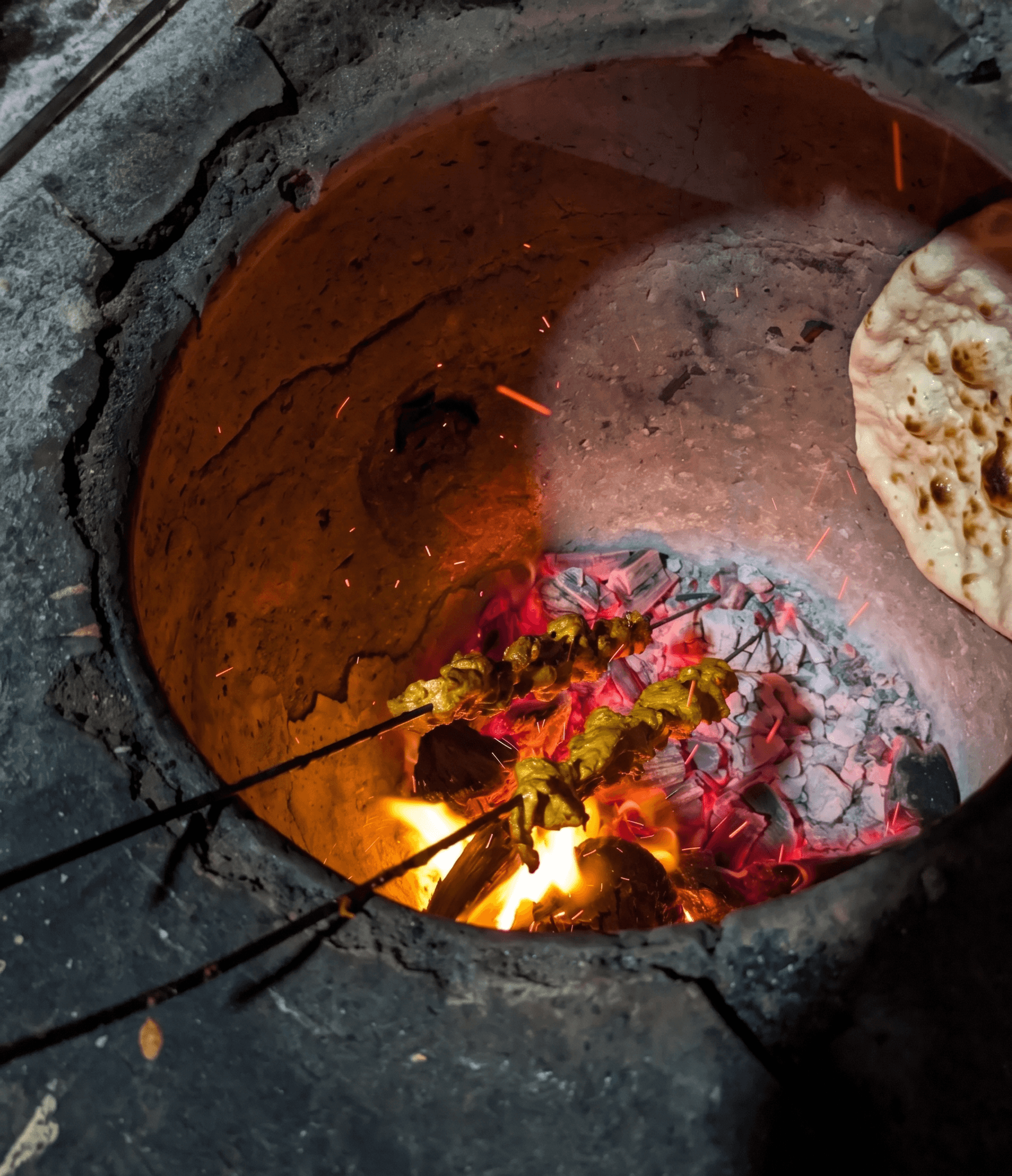 Kebabs and naan roasting inside a live clay tandoor at Hotel Chul